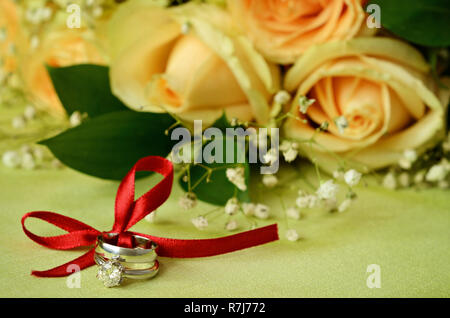 Verlobung und Hochzeit Ringe mit Blumen Stockfoto