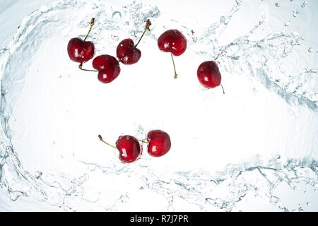 Freeze Motion Kirschen Wasser spritzen auf weißem Hintergrund Stockfoto