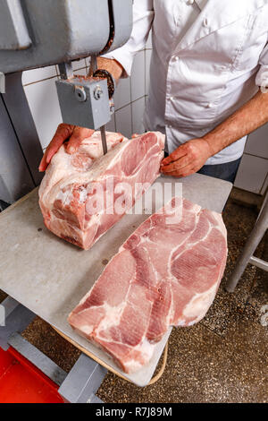 Metzgerei Konzept, schneidet er gefroren Schweinefleisch Stockfoto