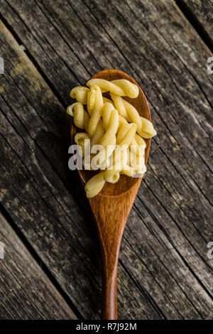 Nicht gegartem Spinat gemelli Pasta in Löffel aus Holz. Stockfoto