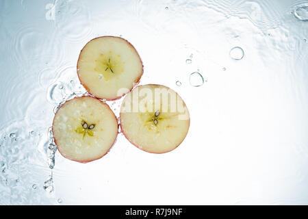 Äpfel Spritzwasser auf weißem Hintergrund Stockfoto