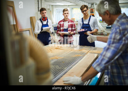 Senior Tischler zeigen, wie mit Holz zu arbeiten Stockfoto