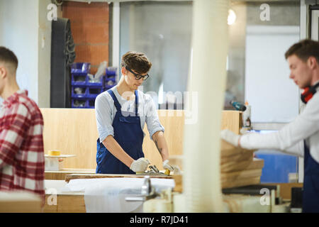 Junge Tischler mit Planer in der Werkstatt Stockfoto