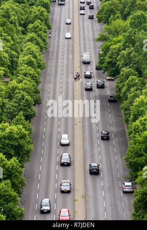 Radfahrer in der Mitte der viel befahrenen Straße mit Autos vorbei am Brandenburger Tor warten auf mehrere Bahnen, Luftaufnahme mit grünen Bäumen, auf den Seiten, Tiergarten Stockfoto