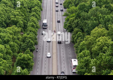 Radfahrer in der Mitte der viel befahrenen Straße mit Autos vorbei am Brandenburger Tor warten auf mehrere Bahnen, Luftaufnahme mit grünen Bäumen, auf den Seiten, Tiergarten Stockfoto