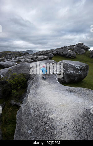 Neuseeland Castle Hill. Kleines Mädchen laufen weg auf den Felsen. Bewölkter Himmel. Grauen rock. Blaue Kleidung. Hut lesen. National Park. Arthurus Berge. Kind. Stockfoto