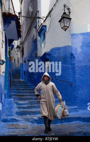 Marokko, Fes, Medina, arabischen Mann, Djellaba hinunter Gasse der blau lackierten Hügel Häuser Stockfoto