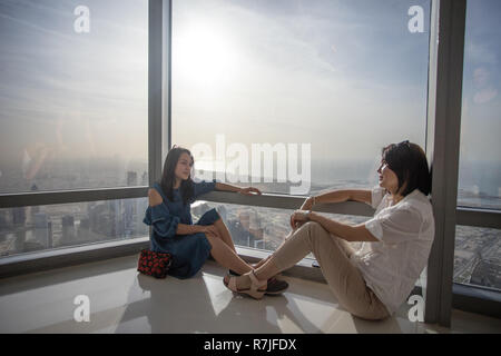 Zwei asiatische weibliche Touristen in der Weltrekord holding Burj Khalia Wolkenkratzer in Dubai, Vereinigte Arabische Emirate. Stockfoto