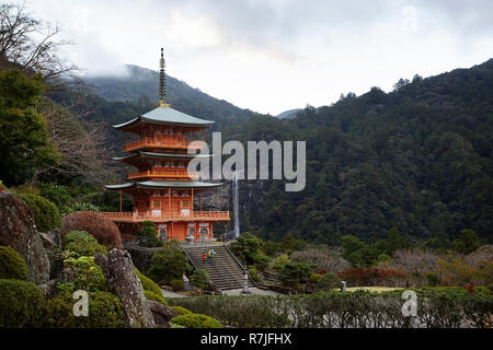 Mutter und Sohn in gelben Jacken wandern tNachisan Seiganto-ji-Pagode in Kumano Nachi Schrein mit Nachi fällt im Hintergrund, Wakayama, Japan, Asien Stockfoto