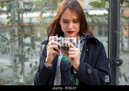 Outdoor herbst Lächeln lifestyle Portrait von hübsche junge Frau, Spaß in der Stadt mit der Kamera, Reisen Foto des Fotografen. Stockfoto