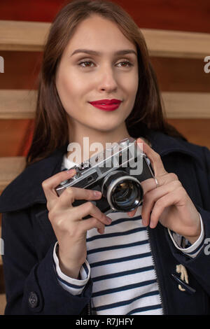 Glückliche junge Hipster Frau hält retro Foto Kamera Stockfoto