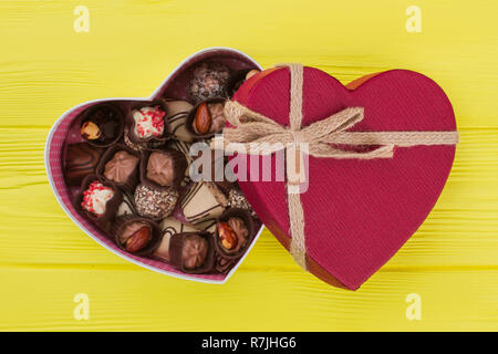 Gemischten Pralinen in Herzform. Leckere Süßigkeiten auf Holz- Hintergrund. Liebe und romantik Konzept. Happy Valentines Tag. Stockfoto