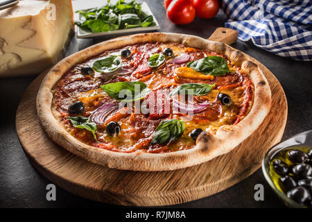 Pizza diavolo traditionelle italienische Speisen aus würzigen Salami Peperoni chili Zwiebel Oliven und Basilikum. Stockfoto