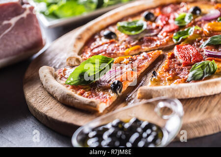 Pizza diavolo traditionelle italienische Speisen aus würzigen Salami Peperoni chili Zwiebel Oliven und Basilikum. Stockfoto