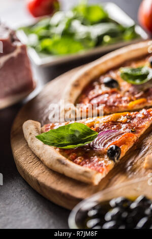 Pizza diavolo traditionelle italienische Speisen aus würzigen Salami Peperoni chili Zwiebel Oliven und Basilikum. Stockfoto