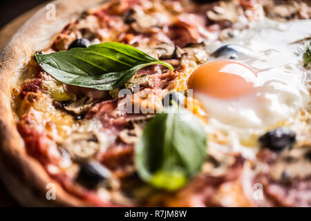 Pizza Capricciosa capricious traditionelle italienische Speisen aus Schinken Champignons Artischocken Eiern parmesan Oliven und Basilikum. Stockfoto