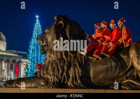 Weihnachtsmänner auf dem Trafalgar Square in London. Stockfoto