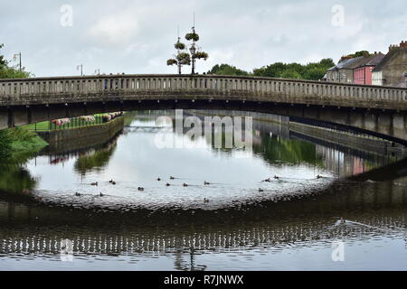 Konkrete Brücke über den Fluss Nore auf ruhigem Wasser Oberfläche in Kilkenny widerspiegelt. Stockfoto