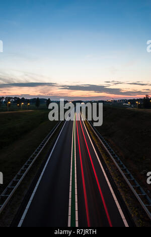Rote und weiße Lichter der Autos auf viel befahrenen Highway, während des Abends Stockfoto