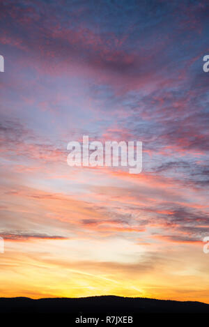 Dramatische Himmel mit großen Wolken im Sonnenuntergang. Die Sonne ist schön bricht durch die Wolken. Vertikale Stockfoto