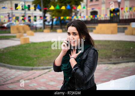 Emotional positive junge Frau spricht auf zelluläre Stockfoto