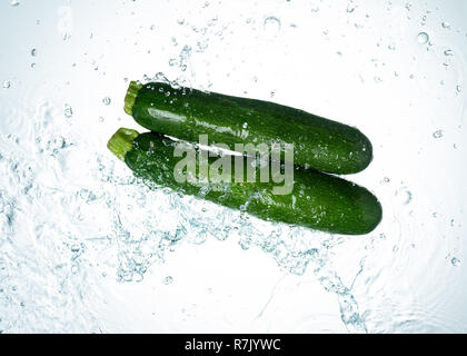 Zucchini Spritzwasser auf weißem Hintergrund Stockfoto