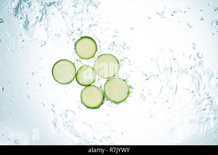 Zucchini Spritzwasser auf weißem Hintergrund Stockfoto