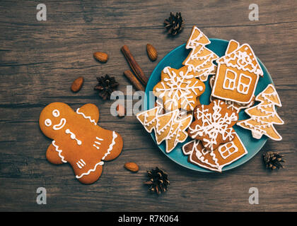 Weihnachten Lebkuchen Draufsicht klassische Weihnachtsplätzchen auf einem blauen Platte und Lebkuchen Mann liegen auf einem Schreibtisch aus Holz mit Zimt und Mandeln Stockfoto