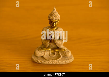 Die Abbildung eines Buddha meditierend auf einem Holztisch Stockfoto