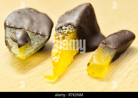 Leckere dunkle Schokolade Pralinen mit Birne, Orange und Ingwer auf einem hölzernen Schneidebrett Stockfoto