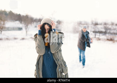 Schneeballschlacht. Winter paar Spaß beim Spielen im Schnee draussen. Junge fröhliche glückliche junge Mann und Frau. Stockfoto