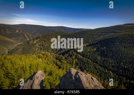 Suche Rysi skaly mit Praded im Hintergrund, Felsen im Vordergrund und grüne Tal voller Nadelbäume unter. Jeseniky Tschechische Republik Stockfoto