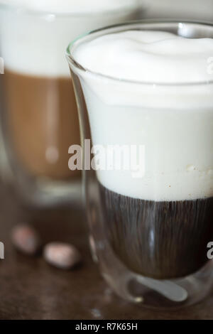 Kaffee mit Milchschaum in ein Glas mit doppelten Wänden. Stockfoto