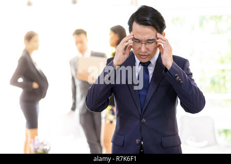 Portrait von Asiatische Geschäftsmann Belastung und erhielt nach für seine Arbeit im Cafe mit Business Team im Hintergrund für coporate Hintergrund nicht gedrueckt Stockfoto