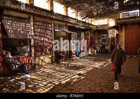 Marokko, Fes, Fes el Bali, Medina, talaa Kebira, halbschattig in lokalen kleidung shop Hof Stockfoto