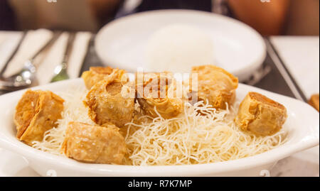 Thai Traditionelle chinesische Essen: Frittierte Gold Krabbenfleisch Rollen in Tofu Blätter mit süßen Pflaumen Soße. Orientalische Vorspeise, Snack, Hors d'oeuvre, Anlasser Stockfoto