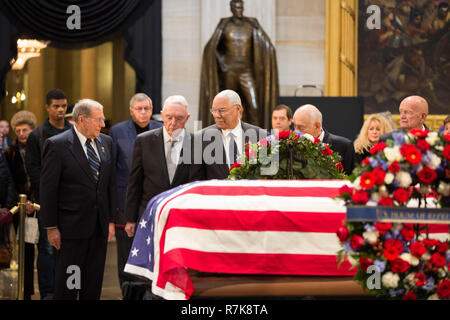 Der frühere Außenminister Colin Powell, Mitte, General Barry McCaffrey, Links, und General John Kelly zahlen ihren Respekt am Flagge drapierte Schatulle des ehemaligen Präsidenten George H. W. Bush als Besucher an, wie es in den staatlichen im Capitol Rotunde Dezember 4, 2018 in Washington, DC liegt. Bush, der 41. Präsident, starb in seinem Haus in Houston Alter 94. Stockfoto