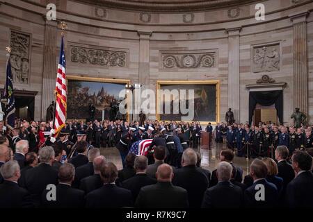 Gemeinsame Service pallbearers Führen der Flagge Schatulle des ehemaligen Präsidenten George H.W. Bush in State Capitol Rotunde Dezember 3, 2018 in Washington, DC, drapiert. Bush, der 41. Präsident, starb in seinem Haus in Houston Alter 94. Stockfoto