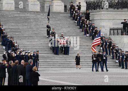 Gemeinsame Service pallbearers Führen der Flagge - drapierte Schatulle des ehemaligen Präsidenten George H.W. Bush auf der Treppe des U.S. Capitol für die Prozession zum Staatsbegräbnis Dezember 5, 2018 in Washington, DC. Bush, der 41. Präsident, starb in seinem Haus in Houston Alter 94. Stockfoto
