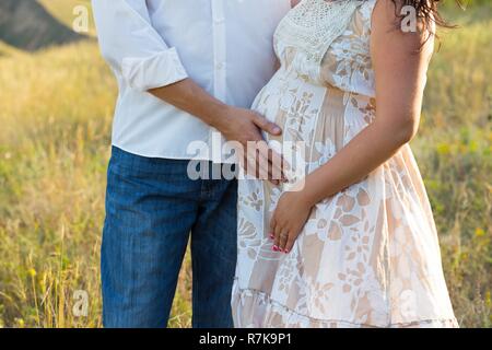 Schwangerschaft - ein Mann legte seine Hand auf seine Frau schwanger Bauch Stockfoto