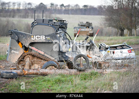 Eigenständige Foto einer unbemannten robotischen autonomen JCB Bagger, für Hosen und Hindernisse überwinden, bewegt sich Stacheldraht und einem havarierten Fahrzeug auf Salisbury Plain während der Übung autonomen Krieger 18, wo Militär, Behörden und Partnern aus der Industrie nehmen teil, die in der Übung autonomen Krieger, Arbeiten mit NATO-Verbündeten in einem bahnbrechenden Übung zu verstehen, wie die militärische Technologie in Roboter und autonome Situationen ausnutzen kann. Stockfoto