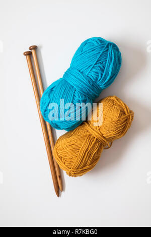 Stricken Hintergrund. Türkis und Orange Wolle mit hölzernen Stricknadeln Stockfoto