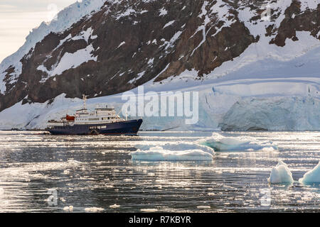 Touristische antarktis Kreuzfahrt in der Lagune zwischen den Eisbergen mit Gletscher im Hintergrund driften, Neco bucht, Antarktis Stockfoto