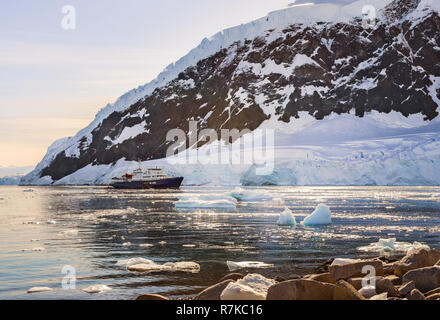 Touristische antarktis Kreuzfahrt in der Lagune zwischen den Eisbergen mit Gletscher im Hintergrund driften, Neco bucht, Antarktis Stockfoto