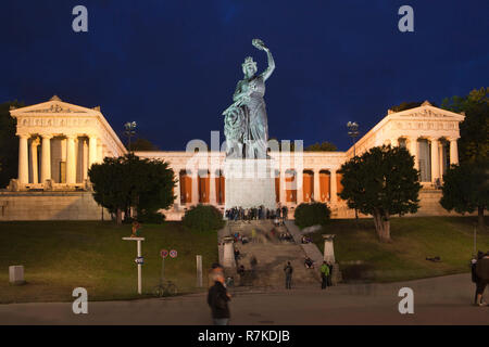 Statue von Bayern (Bronze. Sie besteht aus sandgegossenem, 19. Jahrhundert) und Hall of Fame in München, Deutschland. Schuß in der Nacht während des Oktoberfestes, das in der Nähe stattfindet. Sev Stockfoto