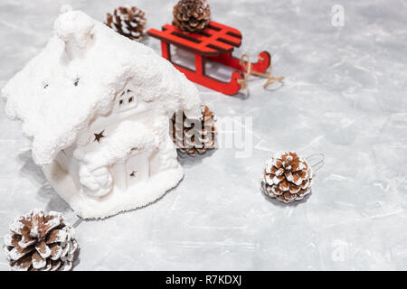 Kunst Weihnachtsferien Zusammensetzung auf hellem Hintergrund Hintergrund mit Christbaumschmuck. New Year's Haus. Schöne Kegel. Neues Jahr Karte. Stockfoto