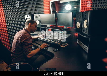 Technologie und Ausrüstung Konzept. Mann zur Kontrolle des Sounds im Studio Stockfoto