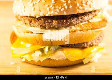 Big Burger mit zwei Koteletts, Käse und Salat. Seitenansicht Stockfoto