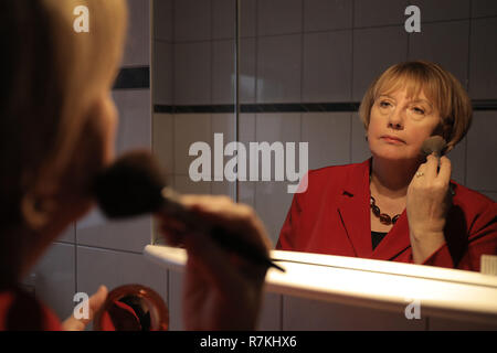 Attendorn, Deutschland. 30 Nov, 2018. Ursula Wanecki, Merkel Doppel, trägt Make-up in ihrer Wohnung. (Dpa: "Büro müde Doppelgängerin: Merkel-Double freut sich auf mehr Ruhe 'Credit): Oliver Berg/dpa/Alamy leben Nachrichten Stockfoto