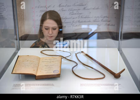 Stuttgart, Deutschland. 10 Dez, 2018. Ein neues Testament und eine Peitsche aus dem Nachlass von Hendrik Witbooi sind in einer Vitrine im Linden Museum für Völkerkunde. Das Land Baden-Württemberg will die Exponate als gestohlener Kulturgüter zu Namibia im Februar zurück. Beide Objekte werden wieder im Lindenmuseum ausgestellt werden, bis sie zurückgegeben werden. Credit: Marijan Murat/dpa/Alamy leben Nachrichten Stockfoto